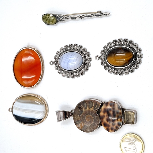 644 - A selection of pendants and brooches some set in sterling silver with hallmarks, featuring agate sto... 