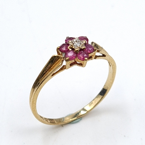 649 - Star Lot: A very pretty diamond ring with ruby surround set in nine carat gold. Stamped 375. Ring si... 