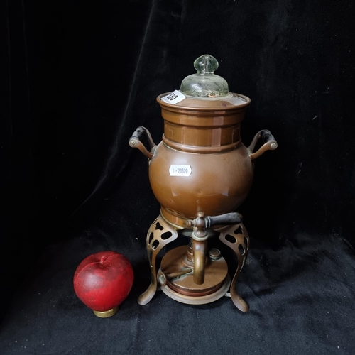 830 - A charming Art Nouveau USA made copper samovar with a tripod base holding a burner, wooden handles a... 