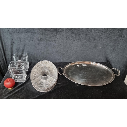 851 - A selection of four items. Includes two glass vase, silver plated double handled serving platter and... 