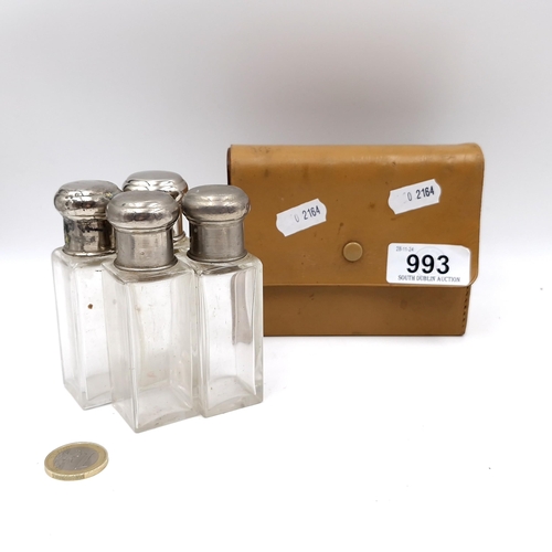 993 - A leather cased set of four glass perfume bottles, all with silver plated tops and inner glass stopp... 