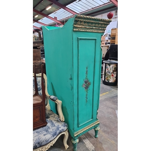 1010 - Star lot : A French Chateau Neoclassical-style turquoise armoire with gilded floral details, double ... 