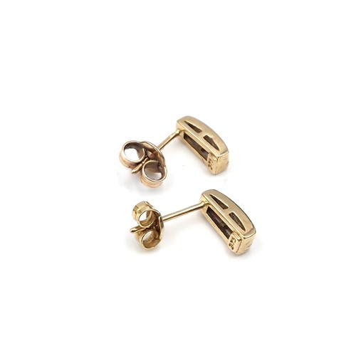 34 - A pair of nine carat gold stud earrings set with diamond accents. Total weight - 1.24 grams. Boxed.