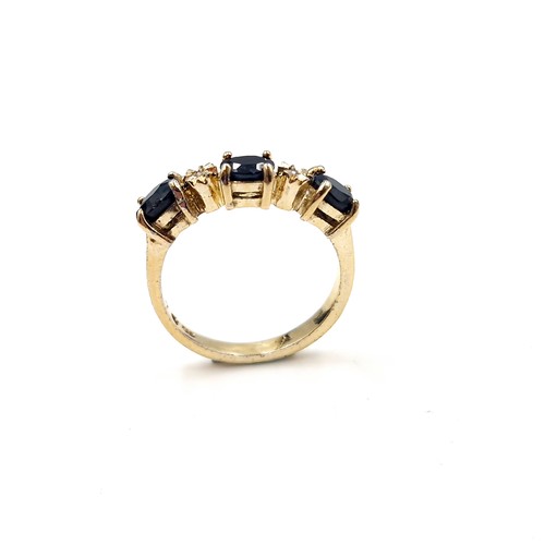 588 - Star Lot : A nine carat gold three stone large sapphire & diamond ring. Size - N 1/2. Weight - 2.75 ... 