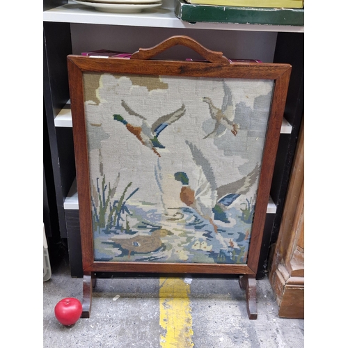 700 - A vintage embroidered tapestry fireguard, showcasing wild ducks gracefully flying across a serene po... 