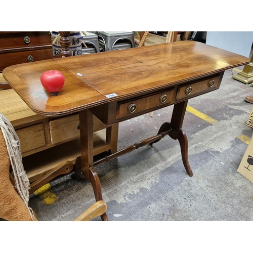 704 - A good quality vintage mahogany drop leaf side table. Features two pull out drawers with brass handl... 