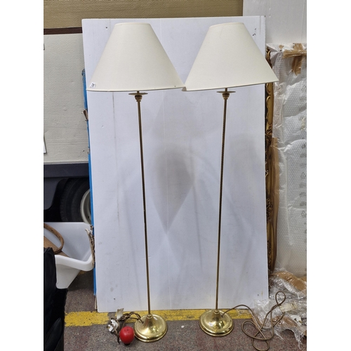 725 - A pair of lovely slender brass floor lamps with matching cream shades.  From the clearance of Dunboy... 