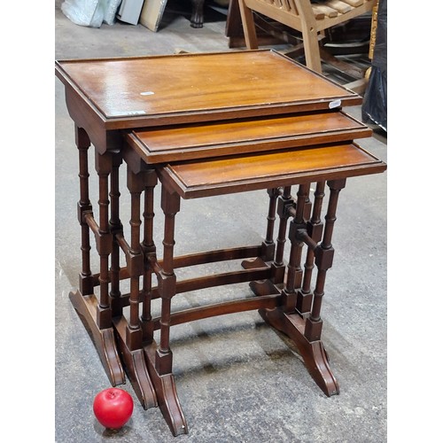 714 - Star Lot : A nest of three vintage mahogany style tables with turned wood pedestals.