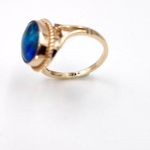 1 - Star Lot : A beautiful nine carat gold fire blue opal ring with dimpled surround. Size - K. Weight -... 