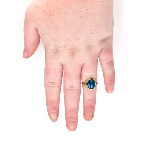 1 - Star Lot : A beautiful nine carat gold fire blue opal ring with dimpled surround. Size - K. Weight -... 