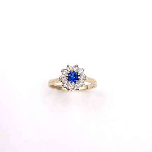 9 - A nine carat gold blue topaz flower ring. Size - M. Weight - 2 grams.