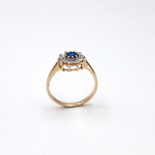 9 - A nine carat gold blue topaz flower ring. Size - M. Weight - 2 grams.