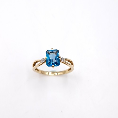 13 - Star Lot : An unusual raised nine carat gold blue topaz and diamond ring. Size - O. Weight - 2 grams... 