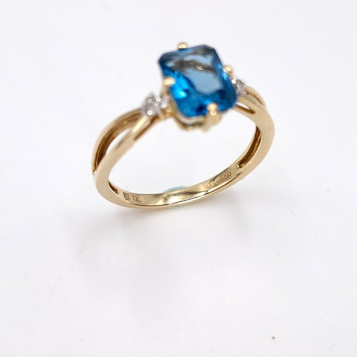 13 - Star Lot : An unusual raised nine carat gold blue topaz and diamond ring. Size - O. Weight - 2 grams... 