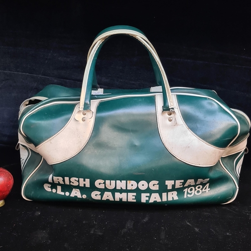 97 - A very retro O'Neills green and white leather carrier bag reading 'Irish Gundog Team C.L.A. Game Fai... 