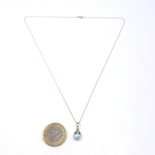 29 - Star Lot : A nine carat gold blue topaz pendant together with chain. Length - 44 cms. Total weight -... 