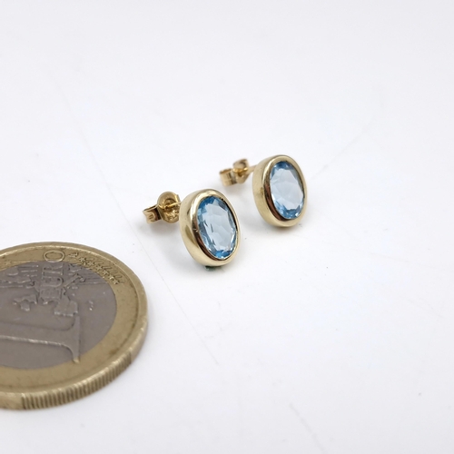 42 - A very pretty nine carat gold pair of bright blue topaz stud earrings. Weight - 1.9 grams.