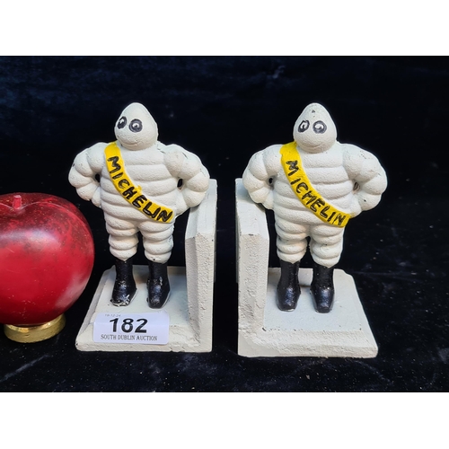 182 - A pair of heavy cast metal bookends in the form of the Michelin Man.