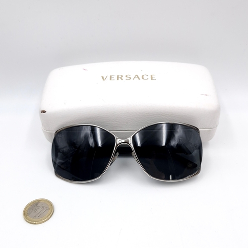 27 - A pair of Versace 'Made in Italy' sunglasses set in white metal frames (Ref: 1308/87). . Comes in or... 