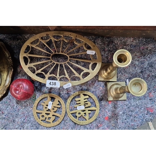 438 - Vintage brass collection includes a trivet, candlesticks, and Chinese-inspired plaques.