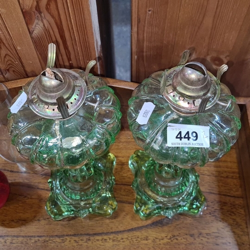 449 - Pair of vintage green glass oil lamps feature ornate design with metal fittings.