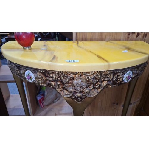 452 - A 1960s Demilune console table with ornate gilt carvings and porcelain medallions. Has a yellow faux... 