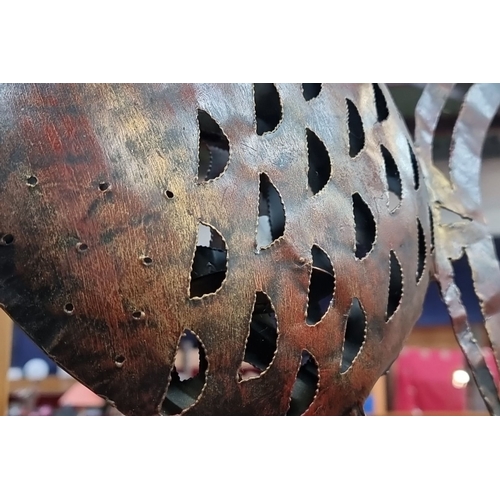 476 - Metal fish sculpture features intricate cut-out details with a rustic patina finish.