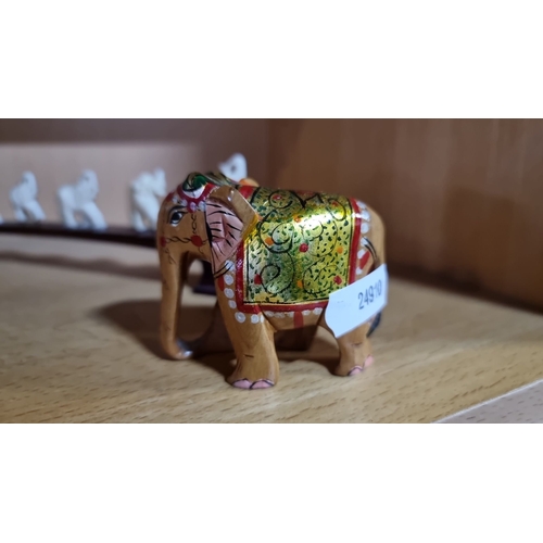 496 - Diverse elephant figurine collection features hand-painted wood, ceramic, and metal, including intri... 