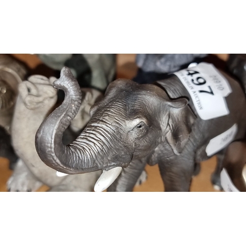 497 - Elephant figurine collection includes diverse materials such as wood, metal, and resin with vibrant,... 