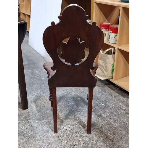 811 - Victorian mahogany hall chair, circa 19th century. The chair features an exquisitely carved backrest... 