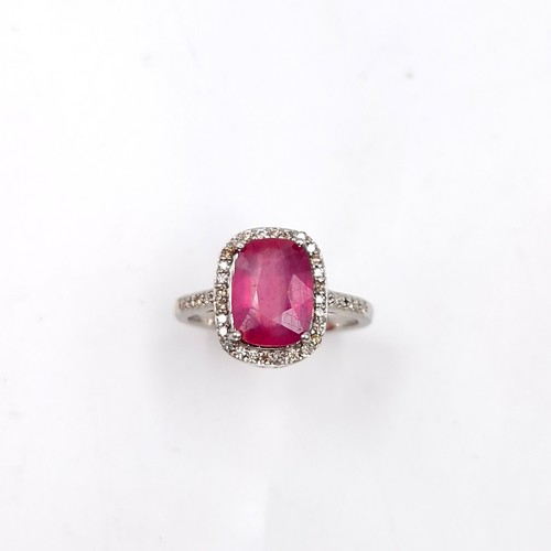 979 - Star Lot : A very fine example of a ruby stone ring with diamond set surround mounted in sterling si... 