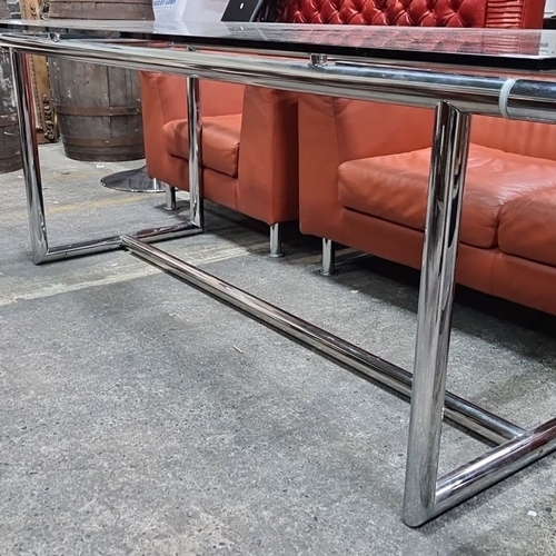 1089 - Star Lot : A large designer Glass-top 8 seater dining table with a steel frame, measuring Almost 8 f... 