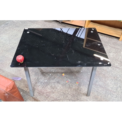 1090 - Black glass top desk, 70x120x75 cm, with silver metal legs, featuring a contemporary design and rect... 