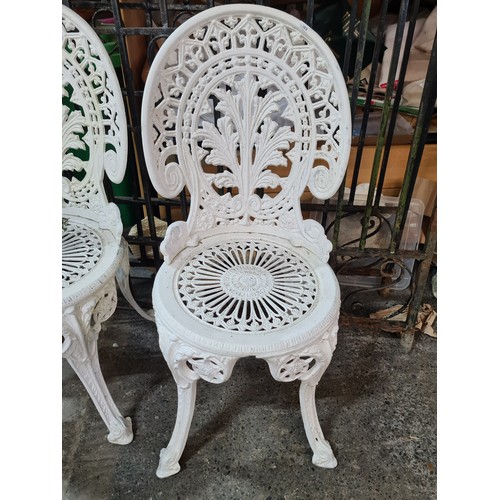 638 - Star Lot : A set of four white metal Garden chairs. Features cabriole legs and pierced floral patter... 