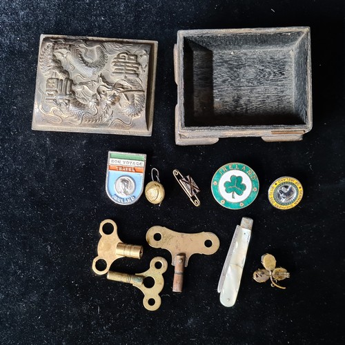 750 - An elegant Japanese lidded storage box featuring a selection of Irish themed badges and a silver poc... 