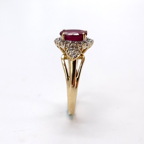 9 - Star lot : A nice example of a ruby stone ring with diamond surround set in nine carat gold. Size - ... 