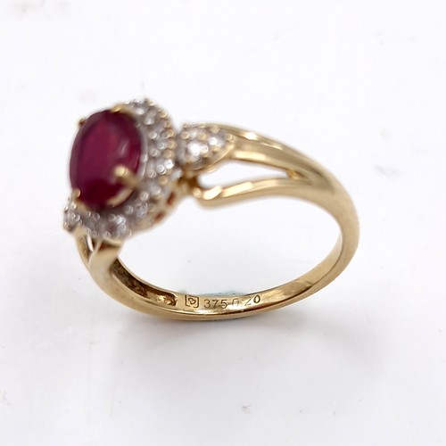 9 - Star lot : A nice example of a ruby stone ring with diamond surround set in nine carat gold. Size - ... 