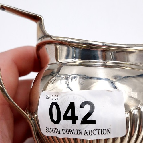 42 - A pretty sterling silver cream jug hallmarked London featuring attractive ribbed body. Length - 11 c... 