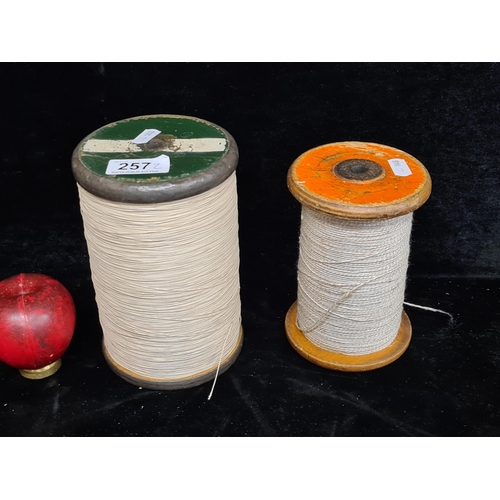 257 - Two  large vintage spools of string Including a wooden and metal example.