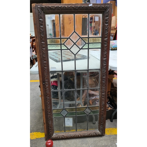 314 - A gorgeous Arts and Crafts stained glass panel. Features carved wooden frame with intricate foliate ... 