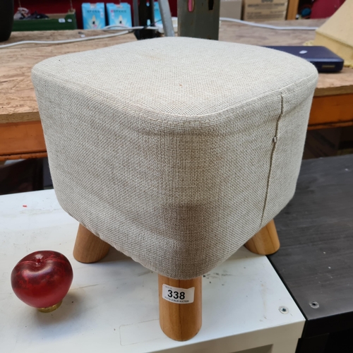 338 - A fun sized cubic foot stool with wood legs and very fresh looking beige fabric.