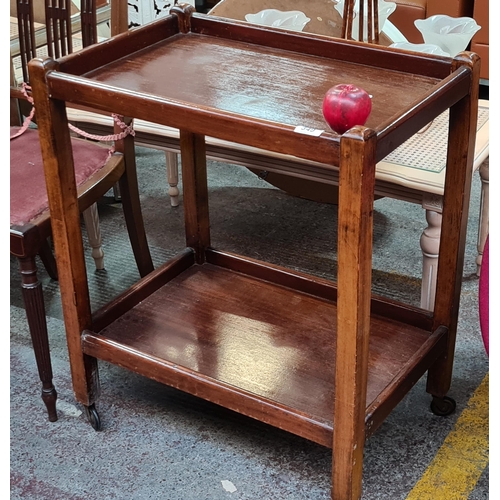 349 - A vintage two tiered  serving trolley sat on caster wheels.