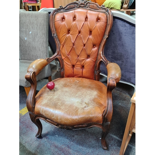 352 - A beautiful Victorian style high back armchair featuring a burnt orange leather upholstery, studded ... 