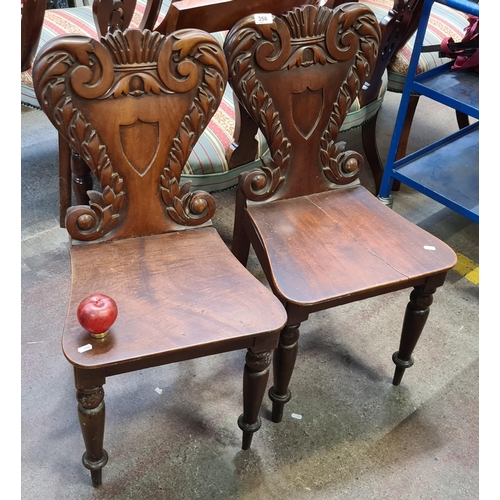 358 - A pair of William the IV mahogany hall chairs with shield shaped motif and tapered legs. Slight dama... 