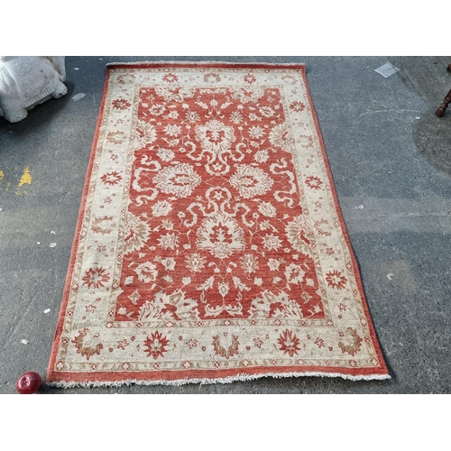 379 - A handsome rust and cream floor rug.
MM: 185cm X 120cm