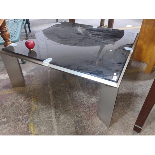 1065 - A sleek and stylish metal framed square coffee table with black glass topped surface.
Previous in au... 