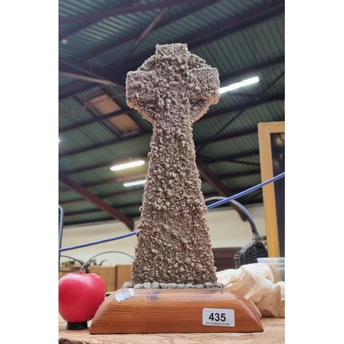 1095 - A hand crafted Irish Celtic Cross adorned with stones mounted onto a wooden plinth base. There is an... 