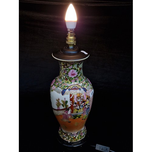 120 - A large Chinese hand painted porcelain table lamp in a Famile Rose style. Mounted on rosewood stand ... 