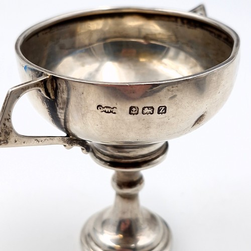 32 - A sterling silver challenge cup hallmarked Birmingham together with ebonised stand. Dimensions: 6 cm... 