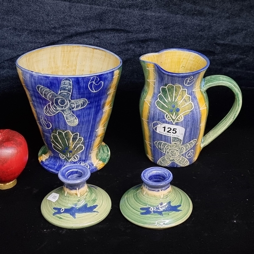 125 - Four pieces of hand painted studio pottery including water pitcher, vase and a pair of candlesticks ... 